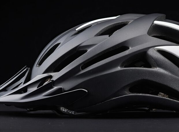Capacete de ciclismo de perfil sobre fundo escuro